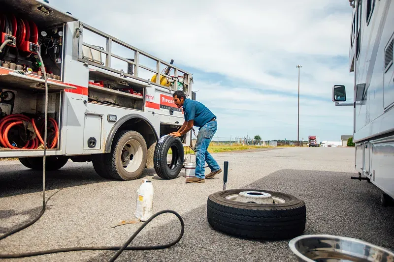 A man is replacing a tire on a vehicle.