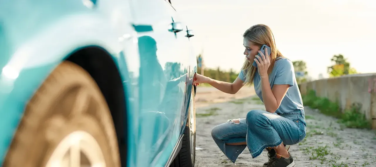 Woman in front of car making a call